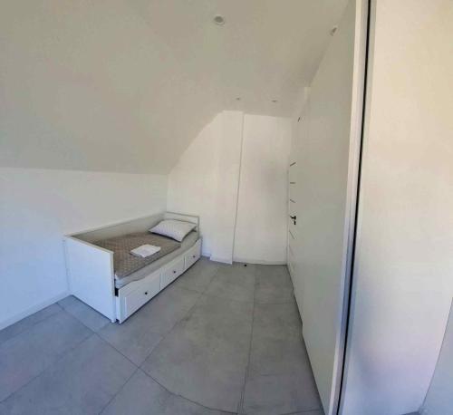 a small white room with a bed in it at Z Widokiem na Wydmę in Łokciowe