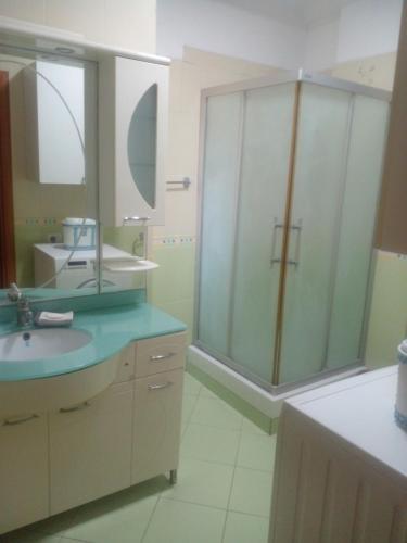 a bathroom with a sink and a large mirror at Ofellows - Kristal Center in Tirana