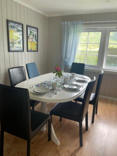 a dining room with a white table and chairs at Krokenes in Sylte