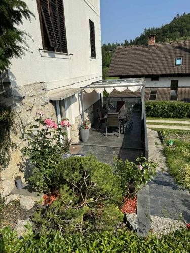 an outdoor patio with a table and chairs and a building at Blue Sky Apartment in Bled