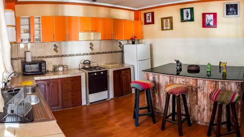 a kitchen with a refrigerator and a counter with stools at Panoramic City View Terrace House , 5 Bedrooms in Cusco