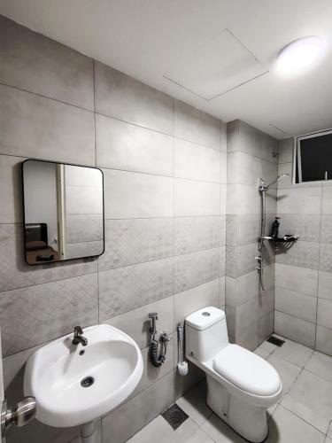 a bathroom with a sink and a toilet and a mirror at Dhia Homestay Sireh Residence Near Aeon Mall in Kota Bharu