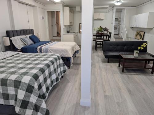 a bedroom with two beds and a living room at Cozy Bachelor Unit in Guelph