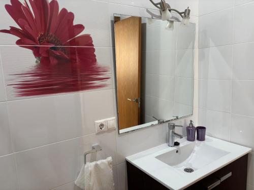 biała łazienka z umywalką i lustrem w obiekcie APARTAMENTO CALMA EN EL CENTRO w mieście Conil de la Frontera