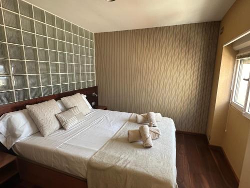 a bedroom with a bed with two stuffed animals on it at Apartamento PLAYA PEQUEÑA LUXURY in Benidorm