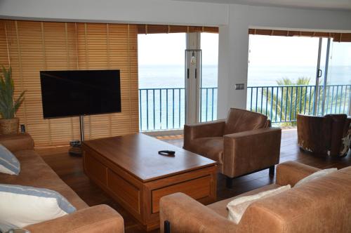 a living room with a television and a couch and chairs at Apartamento PLAYA PEQUEÑA LUXURY in Benidorm