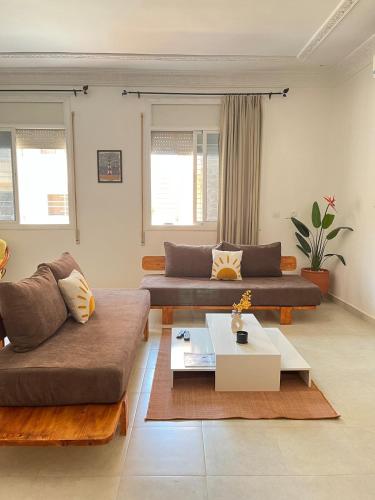 a living room with two couches and a coffee table at Apartment in town, 5 min walk to beach access in Saidia 