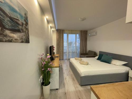 a hotel room with a bed and a couch at Студио Симона 2 - първа линия море in Lozenets