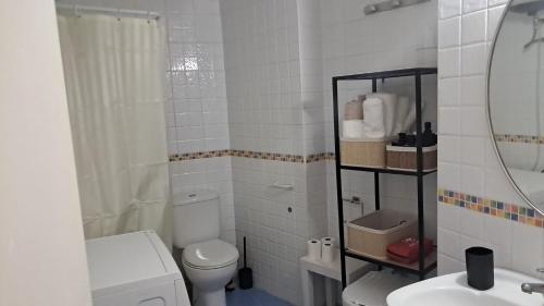 een witte badkamer met een toilet en een wastafel bij Apartamento Grau de Gandía in Gandía