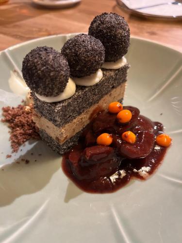 a piece of cake with chocolate and toppings on a plate at Strunzova Pila - apartmány s wellness 2,06 a 3,03 in Kvilda