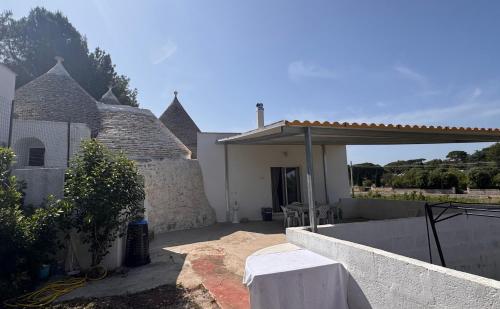 a white house with a patio and a wall at Casa Daniel in Selva di Fasano