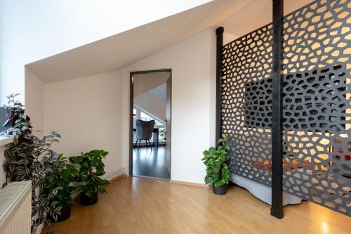 a hallway with a wall with a mirror and plants at Urban Bloom apartments by Booky in Liptovský Mikuláš