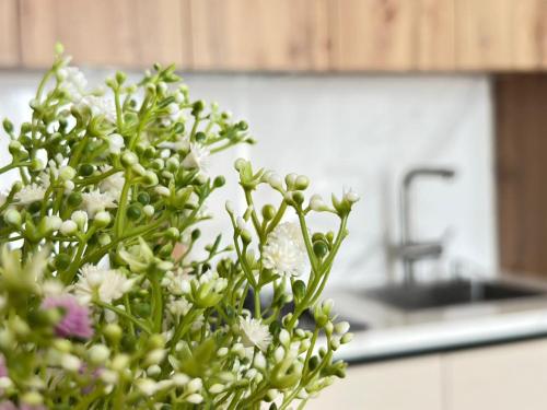 a bouquet of white flowers in a kitchen at Home Side Apartment in Batumi