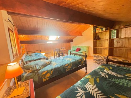 une chambre avec deux lits, une table et une chaise dans l'établissement Au fond du Cirque de Navacelles, à Saint-Maurice-Navacelles