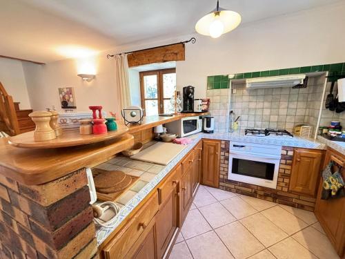 une cuisine avec des armoires en bois et un four à plaques de cuisson dans l'établissement Au fond du Cirque de Navacelles, à Saint-Maurice-Navacelles