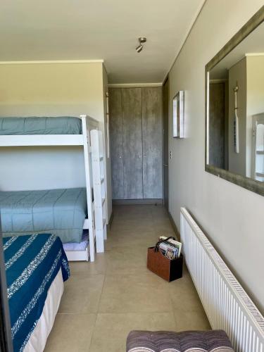 a room with two bunk beds and a mirror at Departamento Banus Marbella piso 1 in Maitencillo