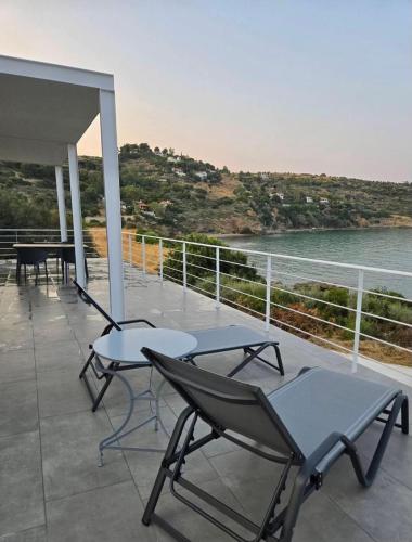 two chairs and a table on a balcony with the ocean at Thalasson Beach House in Koroni