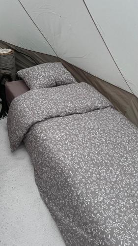 a bed with two pillows in a tent at Elämyksellinen majoitus glamping-teltassa in Kokkola