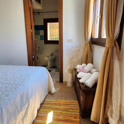 a bedroom with a bed and towels on a table at Tertium Home in Telti