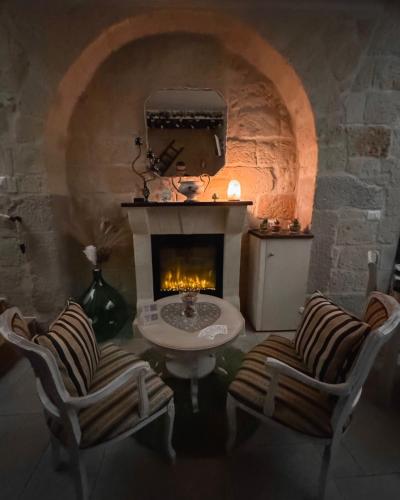 een kamer met een open haard en een tafel en twee stoelen bij BELOVED corato in Corato