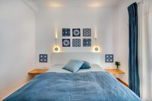 a bedroom with a bed with a blue blanket at Terracotta Room in Moncarapacho