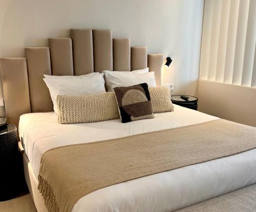 a bedroom with a large bed with white sheets and pillows at Comfy Studios Hotel in Benalmádena