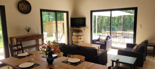 a living room with a table and a couch at La Maison des Chênes in Veyrines-de-Domme