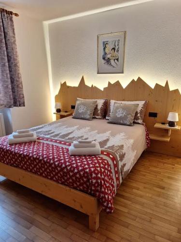 a bedroom with a large bed with a wooden headboard at Appartamento Madama in Falcade