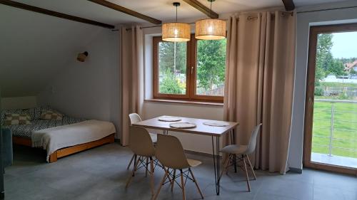 a room with a table and chairs and a bed at Apartamenty u Anety in Wilkasy