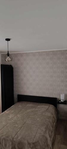a bed in a bedroom with a large headboard at Chez L et L in Sainte-Geneviève-des-Bois