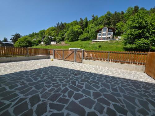 a stone patio with a fence and a house at Villa Bayern in Bakuriani in Bakuriani