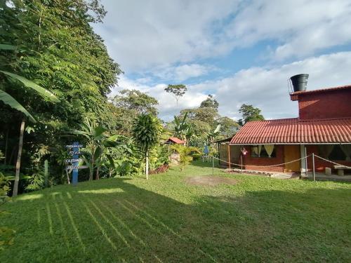 a house with a red roof and a grass yard at Casa Campestre Rancho Texas con jacuzzi y quebrada in La Mesa