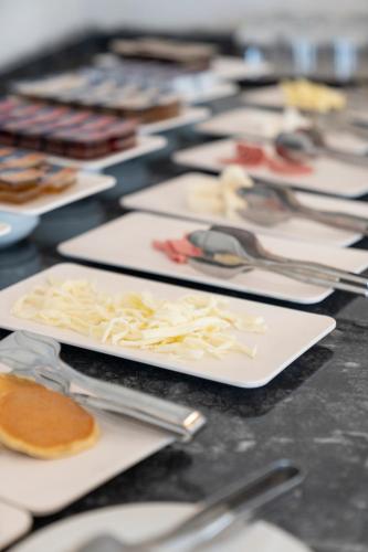 a table topped with white plates of food and silverware at Laristone Suite Spa Hotel in Antalya