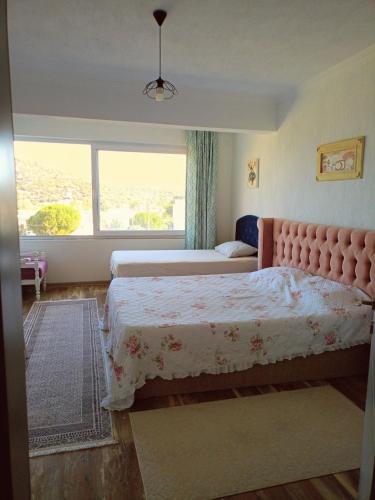 Un dormitorio con dos camas y una gran ventana. en Villa with private pool and unique sea view in Çeşme, en Cesme