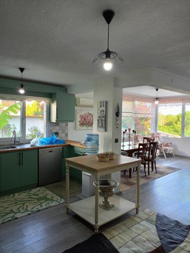 una cocina con armarios verdes y una mesa en Villa with private pool and unique sea view in Çeşme, en Cesme