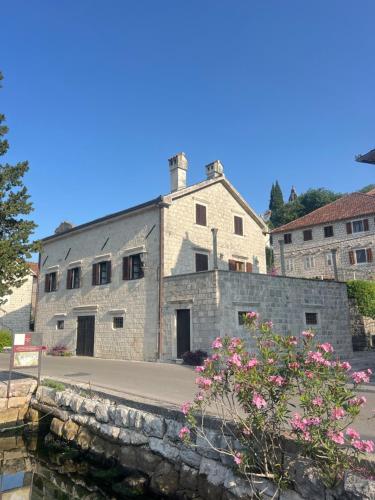 ペラストにあるVilla Sunriseの花の前に建つ古い石造りの建物