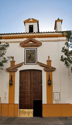 a building with a large door with a clock on top at Apartamento_Santa Isabel in Utrera