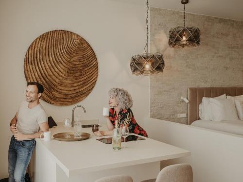 a man and woman standing in a kitchen with a sink at Comfy Studios Hotel in Benalmádena
