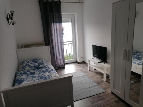 a bedroom with a bed and a tv and a window at Ferienhaus Auf der Höhe in Kirchhain