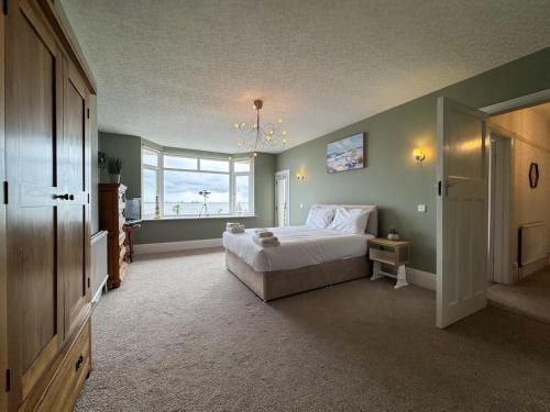 a bedroom with a large bed and a window at Seafront Beach House in Southend-on-Sea