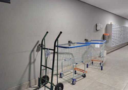 two shopping carts in a room with a wall at Loft Exclusivo no Cittyplex, Estilo & Conforto in Osasco