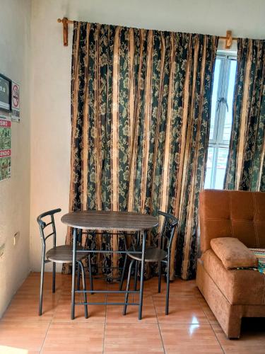 a table and chairs in a room with a curtain at Suite amplia privada a 8 min del centro in Aguascalientes
