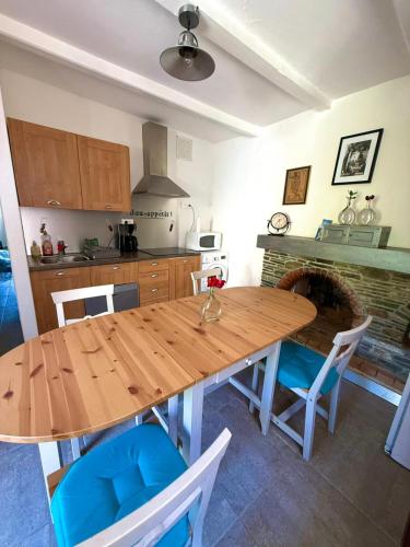 une cuisine avec une table et des chaises en bois dans l'établissement Tour avec rooftop, vue mer, séjour insolite entre ciel et pierre, à Porri