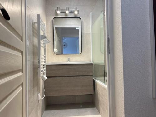 une salle de bains avec un lavabo et un miroir dans l'établissement Résidence Les Hauts de Valmeinier 1900, à Valmeinier