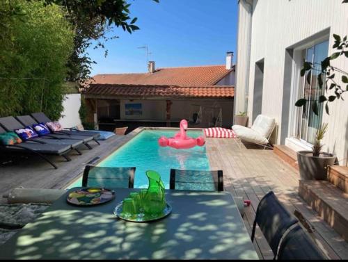 - une piscine avec une table et une table gonflable rose dans l'établissement Villa Etche Ona, chambre chez l'habitant, à Biarritz