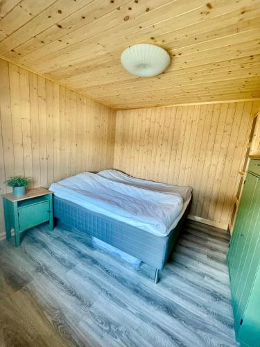 a bedroom with a bed in a wooden room at Hytte sentralt i Myrkdalen in Vossevangen