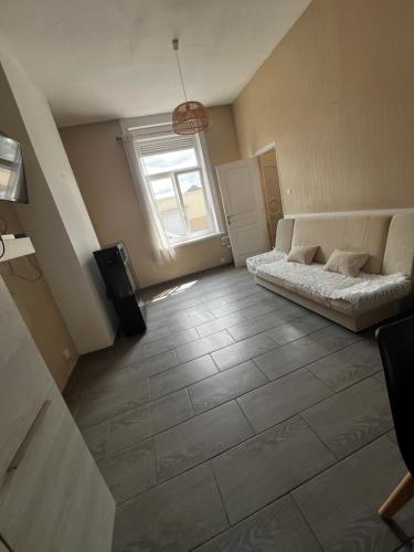 un soggiorno con letto e finestra di Maison proche de toutes commodités a Dunkerque