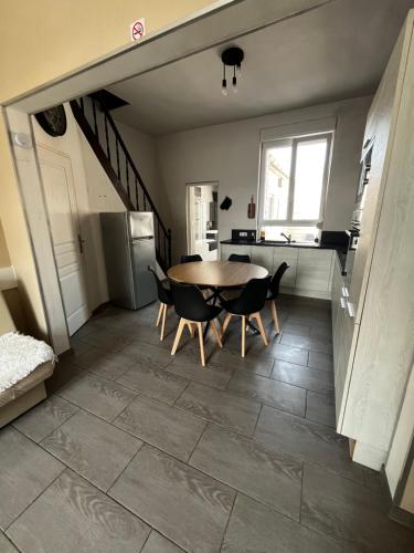 une cuisine et une salle à manger avec une table et des chaises dans l'établissement Maison proche de toutes commodités, à Dunkerque