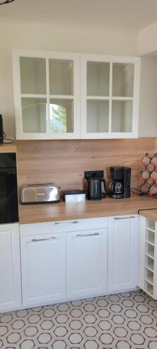 une cuisine avec des armoires blanches et un comptoir dans l'établissement Villa Propriano vue mer, à Viggianello