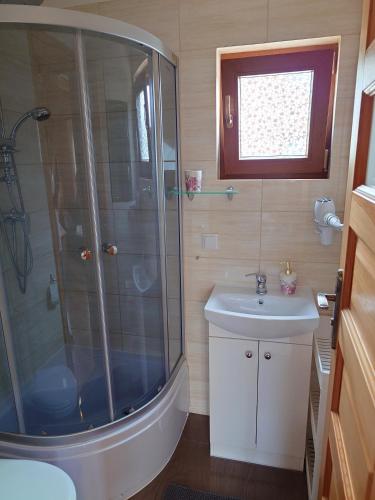 a bathroom with a shower and a sink at Domki u Asi in Wilkasy